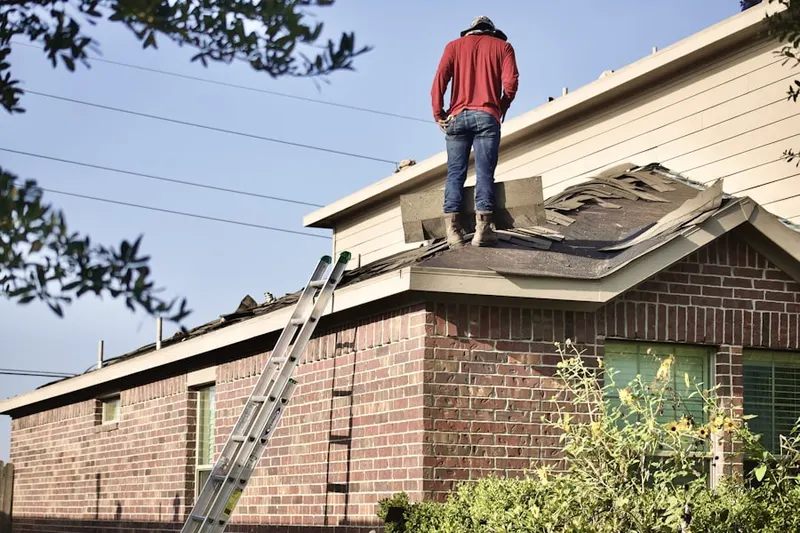 Professional roofer working on a residential roof in Horace Mann
